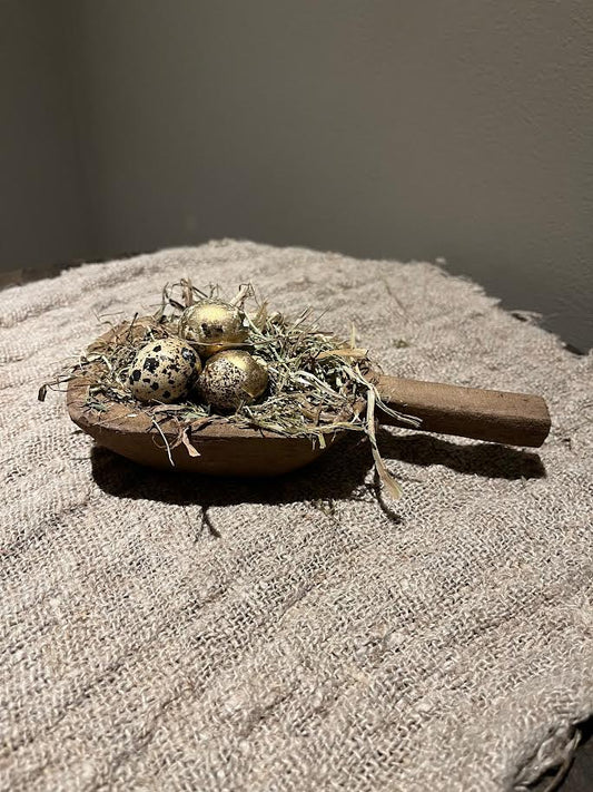 Houten schep met hooi en eitjes